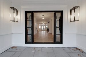 Image of the front door and entry foyer in a 2-story colonial style home in Osterville, MA.