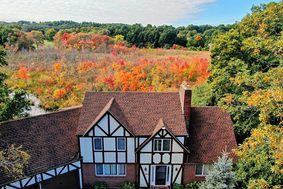 Aerial (drone) image of a 2-story tudor style home in West Needham Heights, MA. 