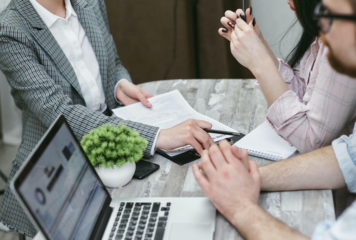 A couple at a table with a title insurance agent discussing the need for title insurance